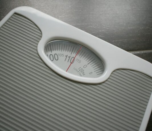 다이어트와 운동: 몸과 마음에 긍정적인 변화를 가져오는 두 가지 주축 a bathroom scale sitting on top of a wooden table