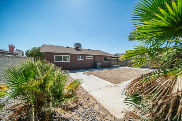 Photo by Brian Wangenheim a brown house with a palm tree in front of it