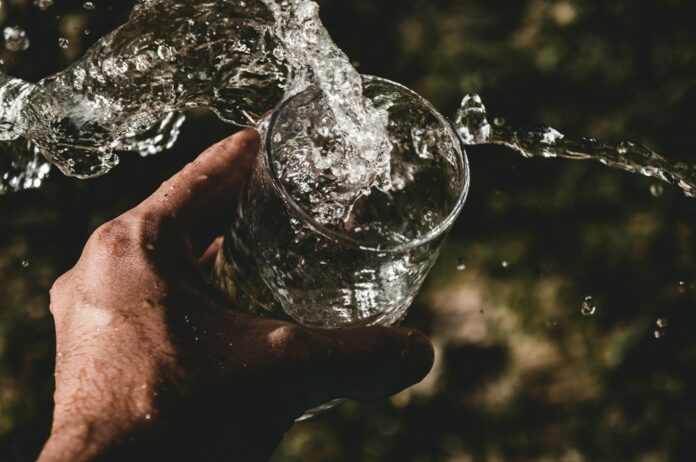Photo by Anderson Rian person holding drinking glass filled with water