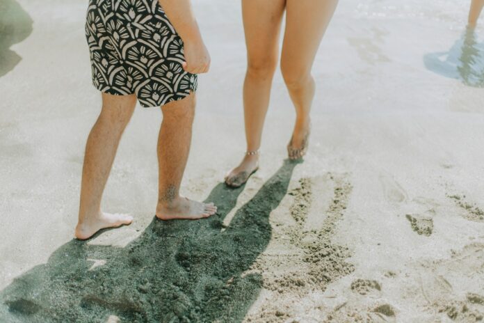 Two people walking on a sandy beach