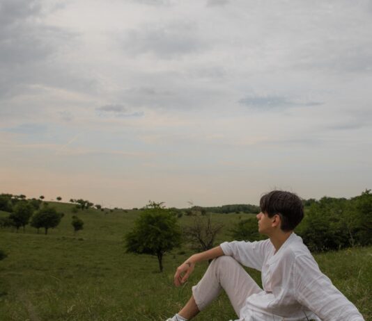 ‘만성피로’ 잡는 법, 최신 생활 트렌드가 바꾼 해법은? a man sitting on a blanket in the middle of a field